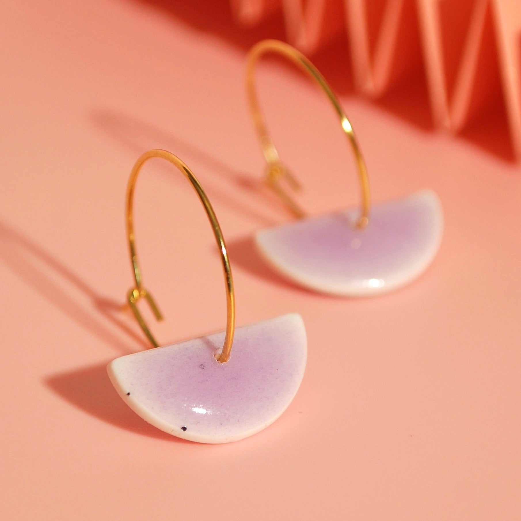 Detailaufnahme der zarten Farben und glänzenden Oberfläche der Ohrringe