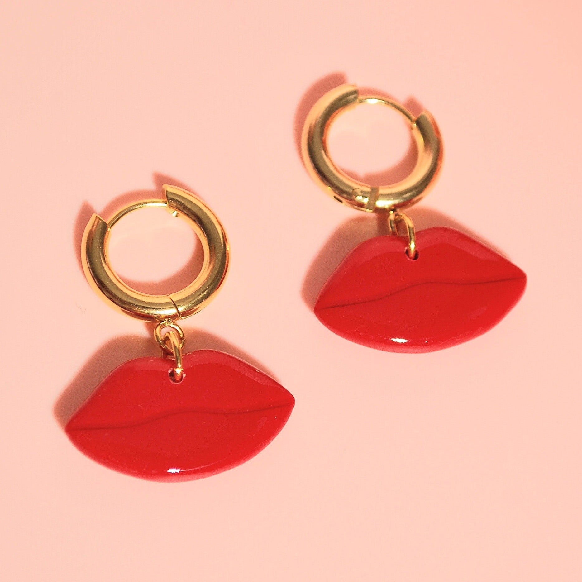 Rote Lippenohrringe auf rosa Hintergrund – Santoclay