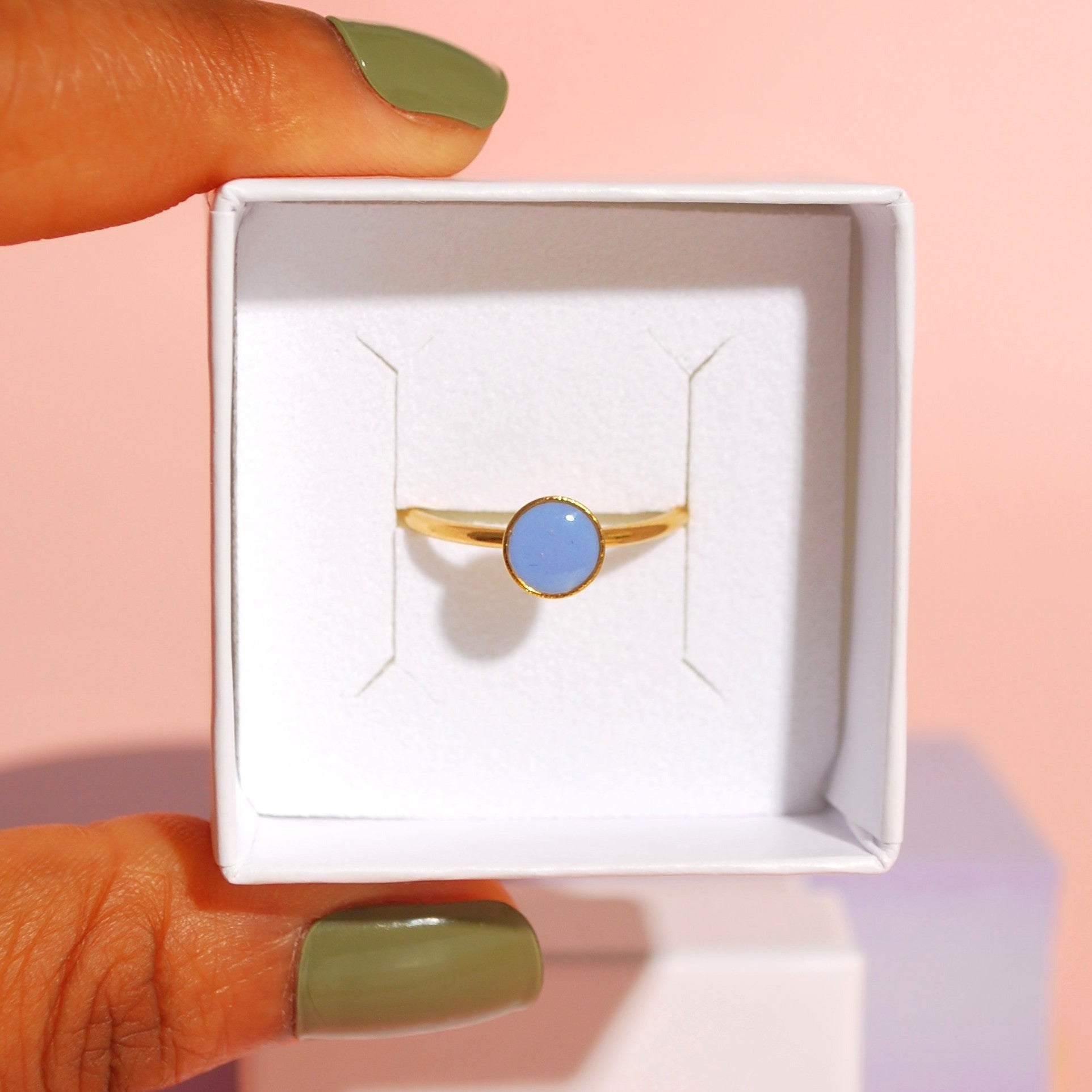 Verstellbarer Ring mit lavendelfarbenem Detail aus Polymerton in weißer Schmuckbox auf Santoclay-Verpackung