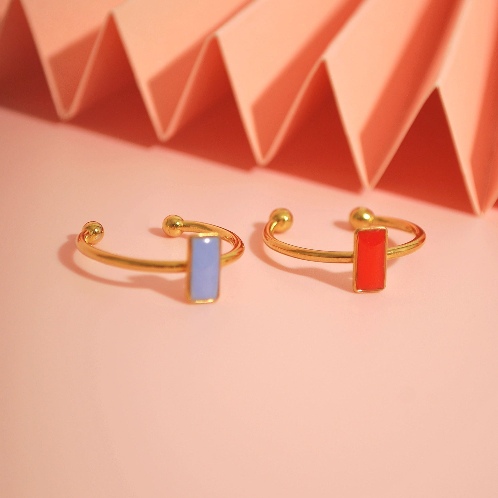 Lavendel- und Orange-Ring nebeneinander auf rosa Fläche