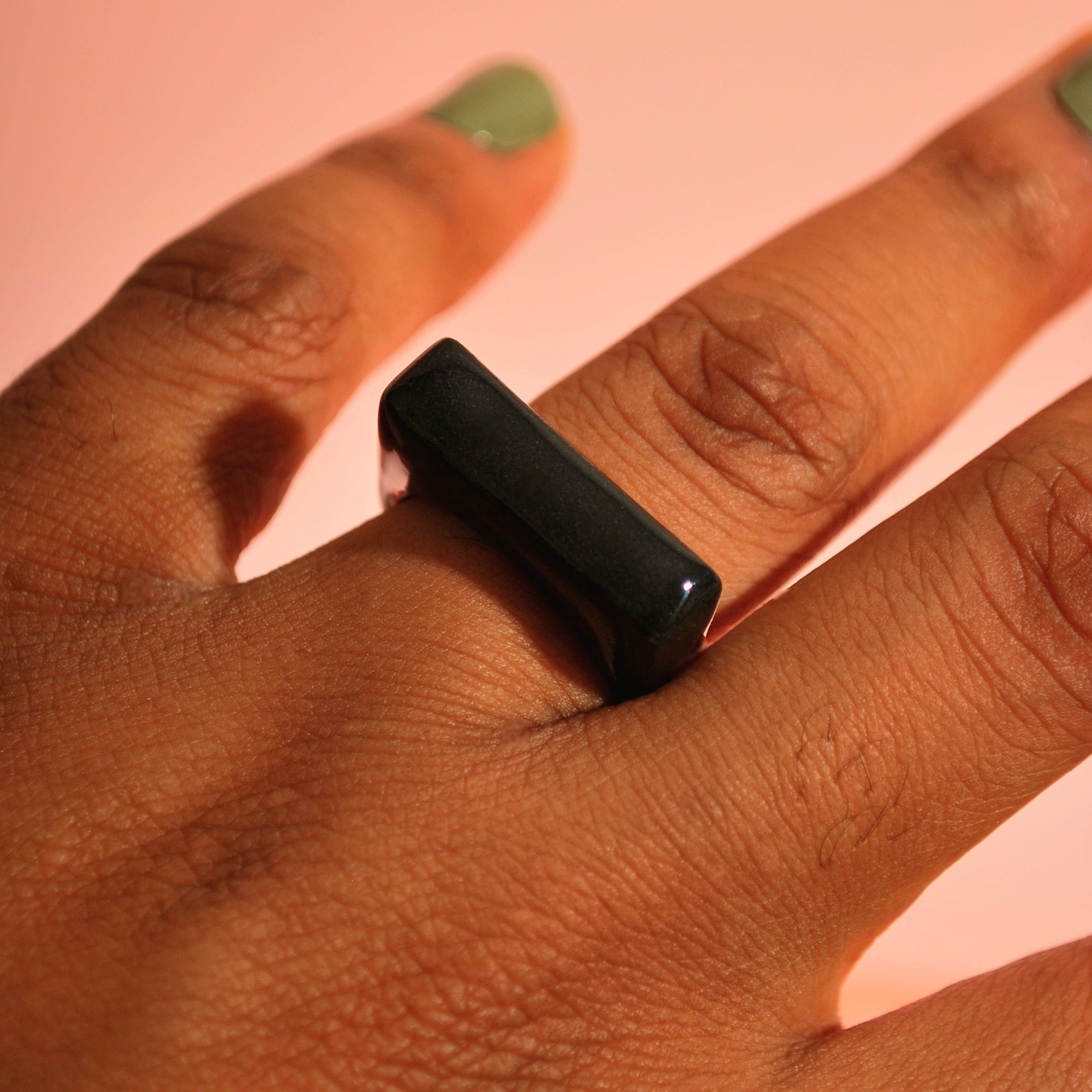 Schwarzer Polymer-Ring an der Hand getragen