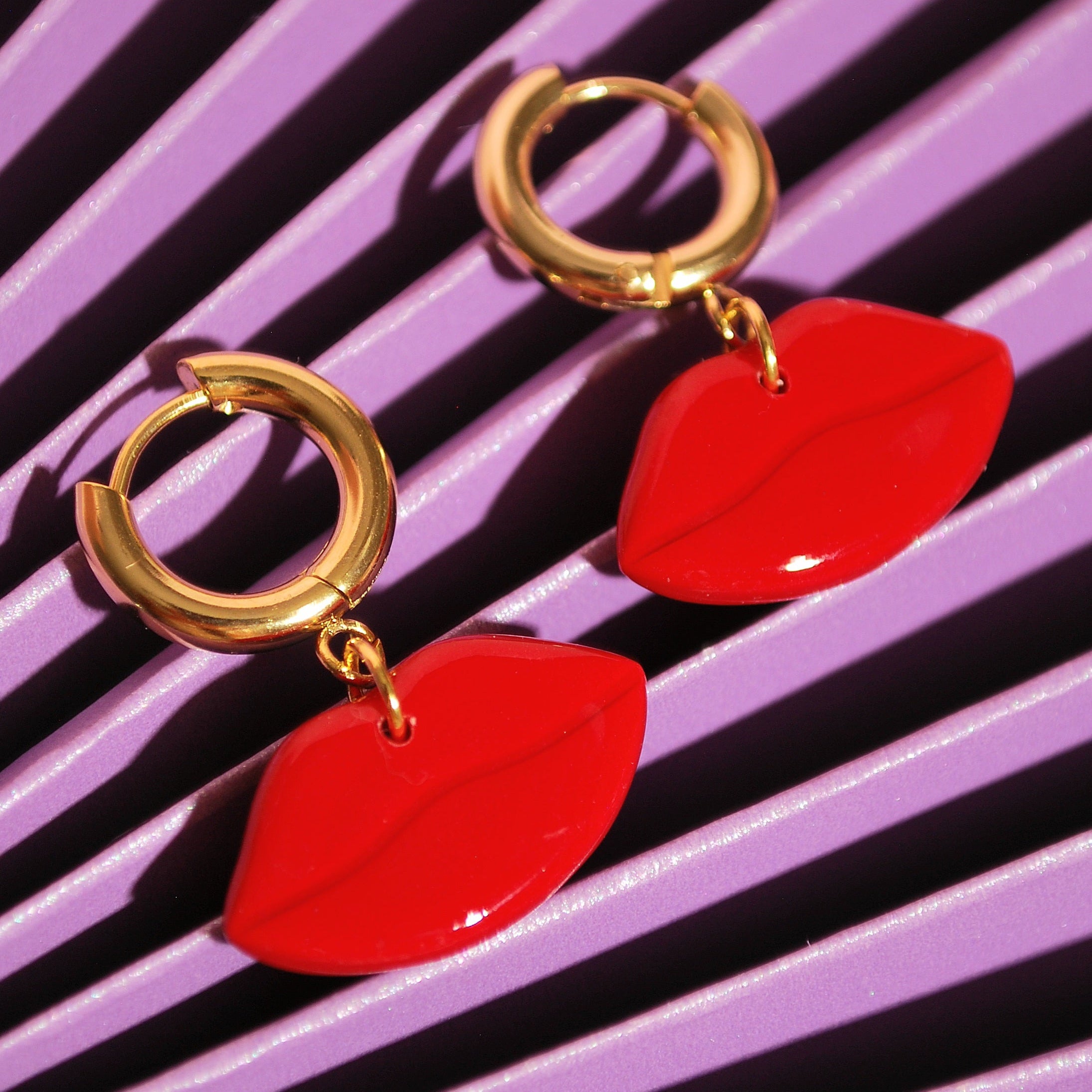 Statement Creolen Red Kiss auf violettem Papierhintergrund