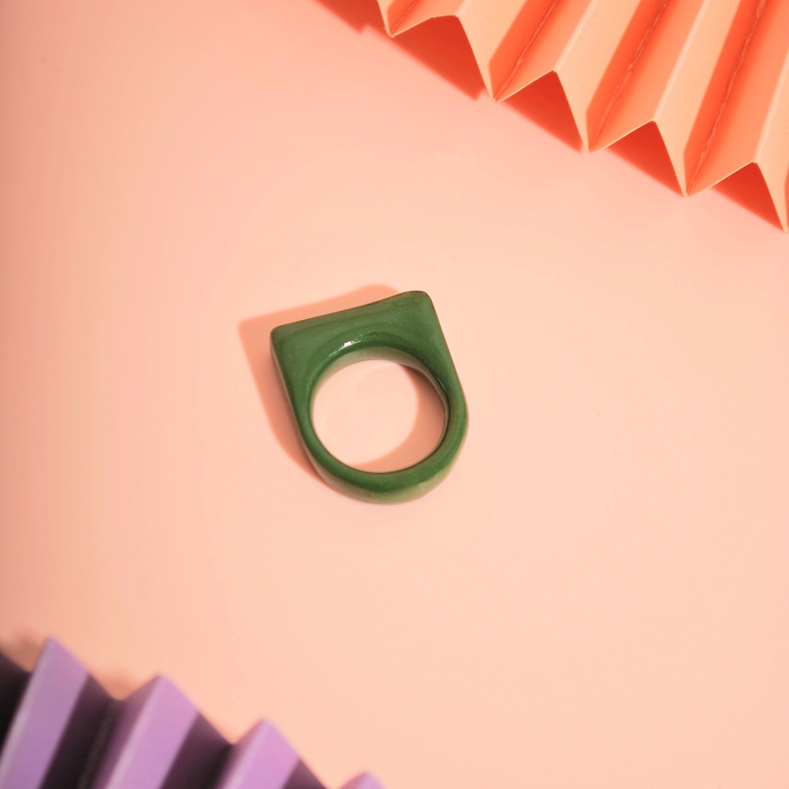 Flacher Ring aus Polymer Ton in Olivgrün auf rosa Hintergrund