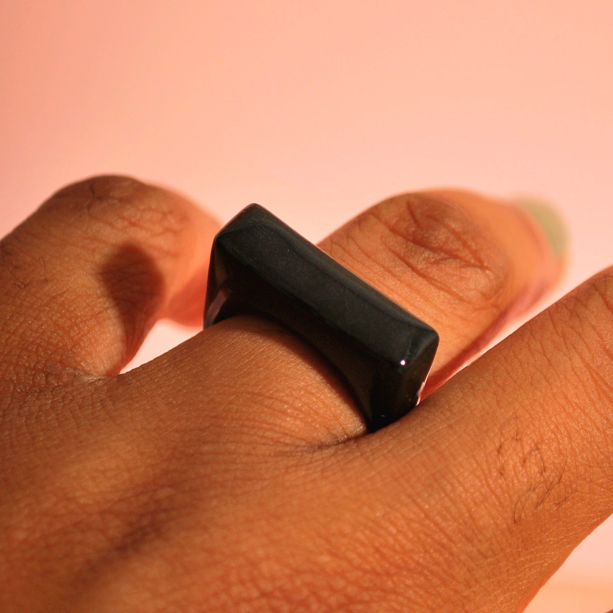 Handgefertigter schwarzer Ring aus Polymer Clay auf Fingern